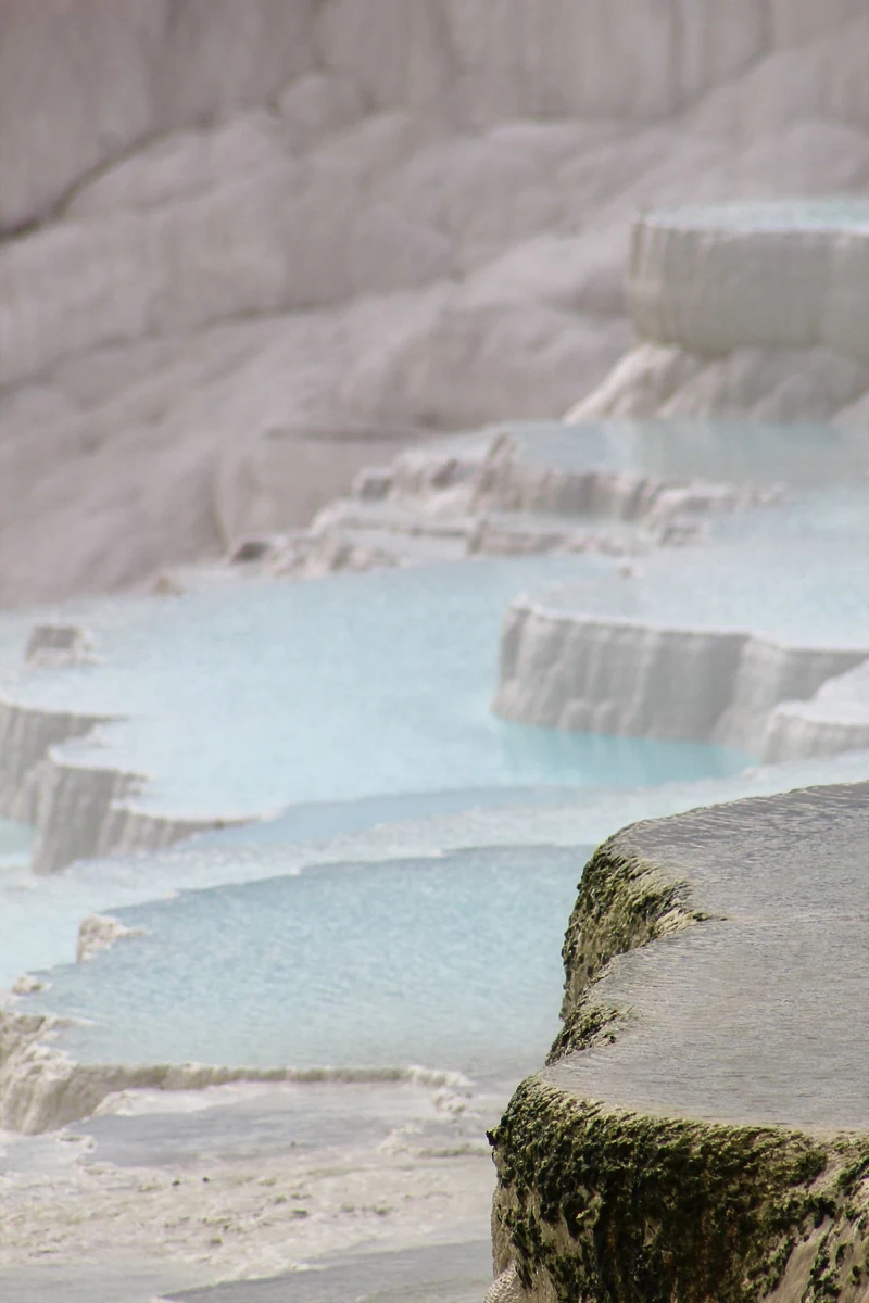 Close view of shallow turquoise water and textured travertine rims at Pamukkale