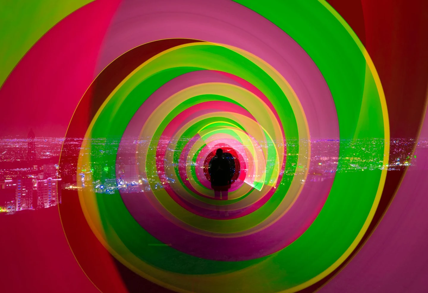 A colourful light-art composition creates a tunnel around a silhouette and city scene. Photo: ali atyabi / Pexels; creative inspiration, not a result from the suggested exercise.