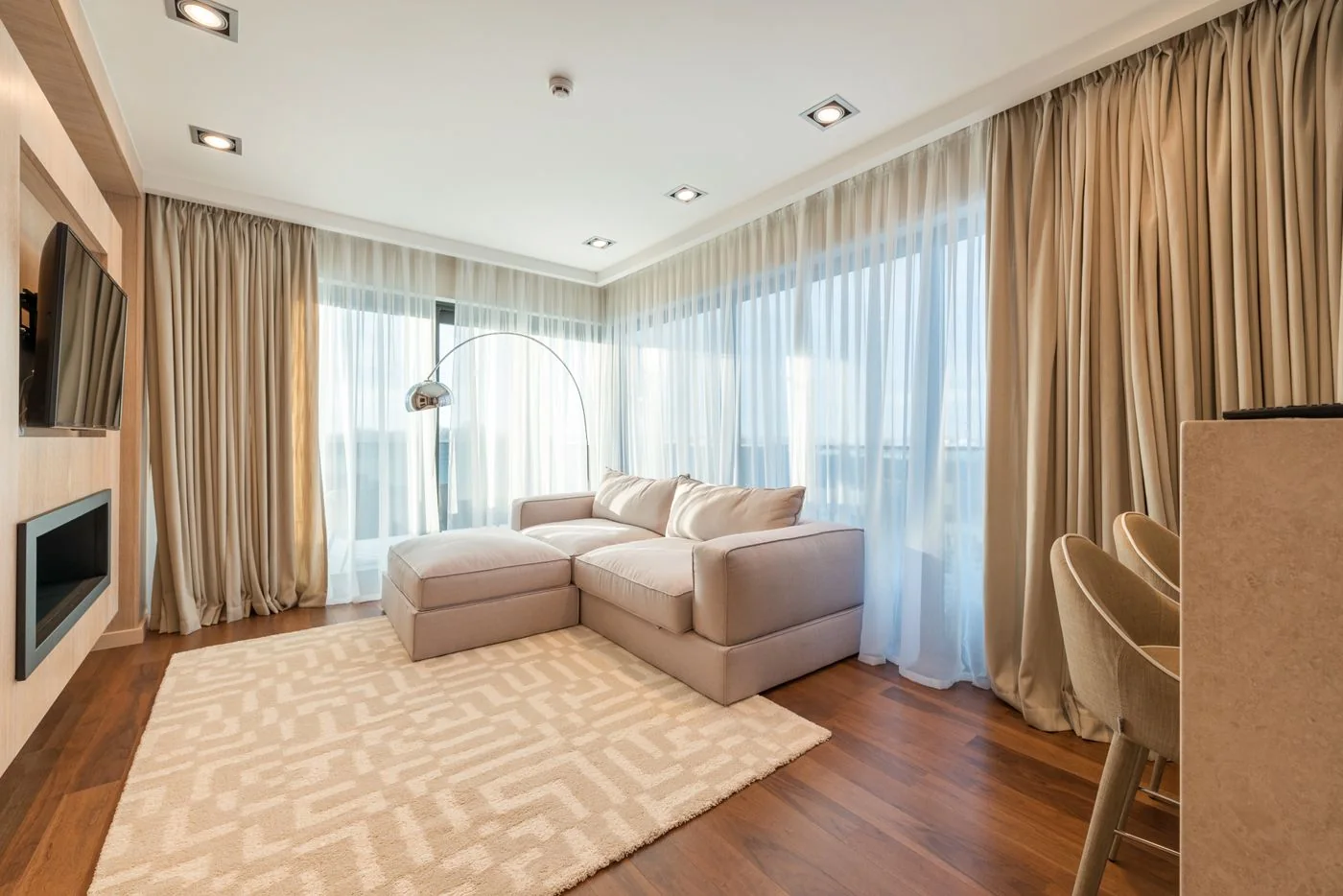 Living room with an upholstered sofa, rug and curtains. Illustrative photograph, not an acoustic absorption test. Max Vakhtbovych / Pexels, Pexels License.